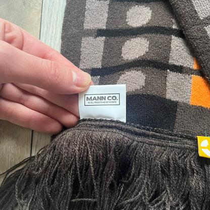Officially licensed Team Fortress 2 merchandise released in 2014 by The Coop. This scarf is made from soft knit material and features a trompe-l’œil bullet bandolier graphic designed to replicate the ammunition belt worn by the Heavy character. Long and warm in construction, it displays repeated cartridge details along the length of the scarf.