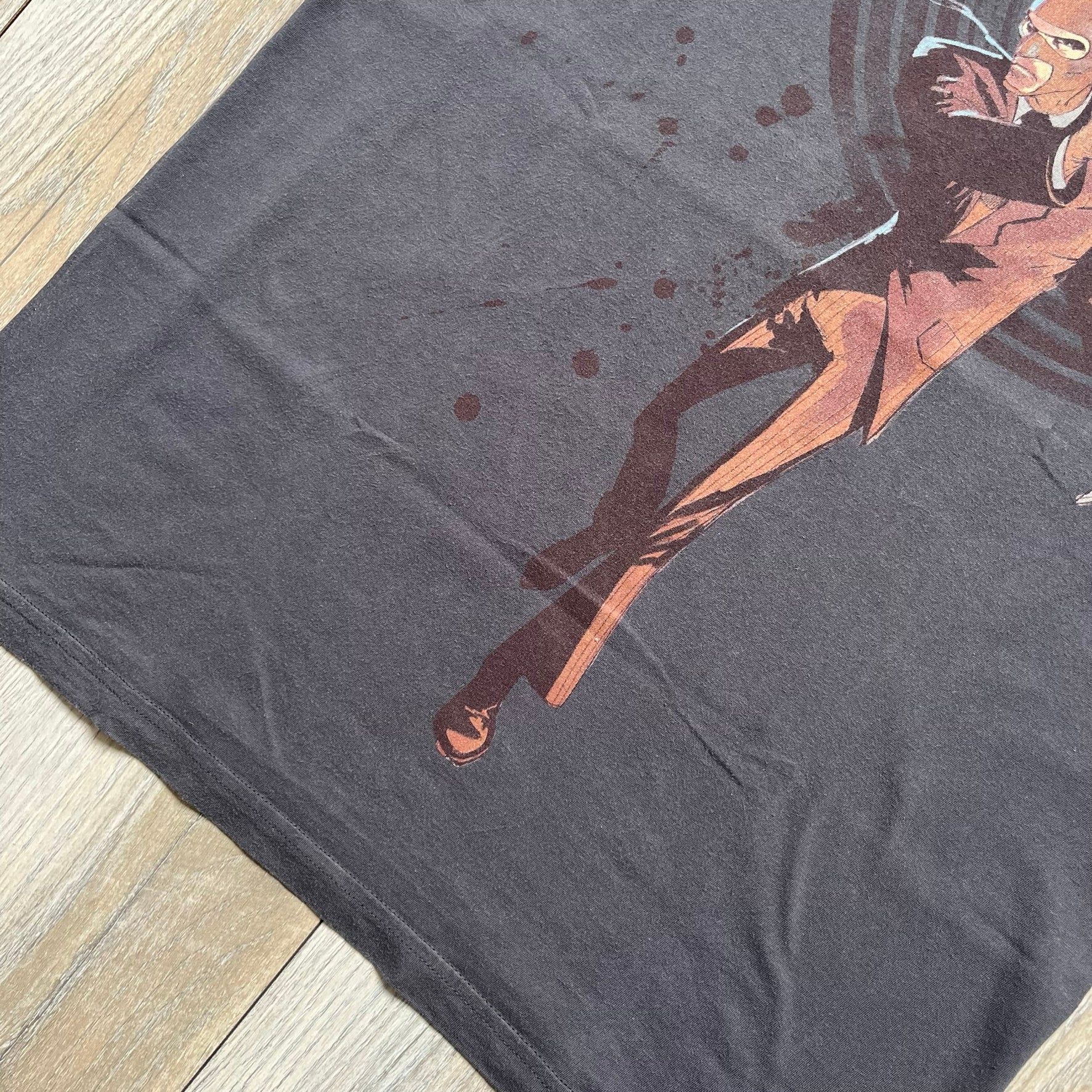 The Team Fortress 2 Red Spy 2010's Gray Tee is an official Valve shirt from the Sniper vs. Spy update, produced during Valve’s Amercian Apparel merch era. This charcoal gray tee features a red Spy character holding a butterfly knife and gun, set against a dark red target graphic with dripping effects. A super rare collectible, it represents one of the original Valve Store releases from over a decade ago.