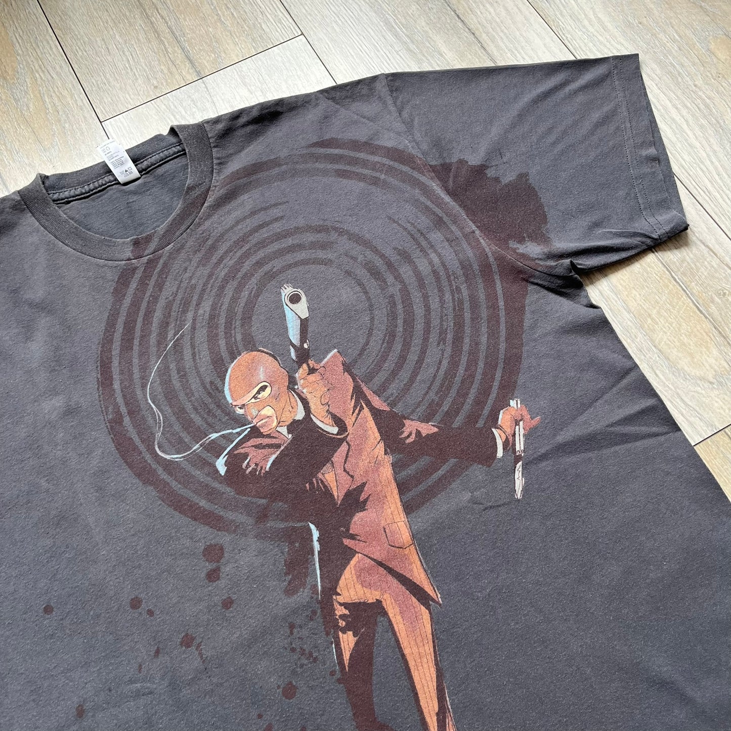 The Team Fortress 2 Red Spy 2010's Gray Tee is an official Valve shirt from the Sniper vs. Spy update, produced during Valve’s Amercian Apparel merch era. This charcoal gray tee features a red Spy character holding a butterfly knife and gun, set against a dark red target graphic with dripping effects. A super rare collectible, it represents one of the original Valve Store releases from over a decade ago.