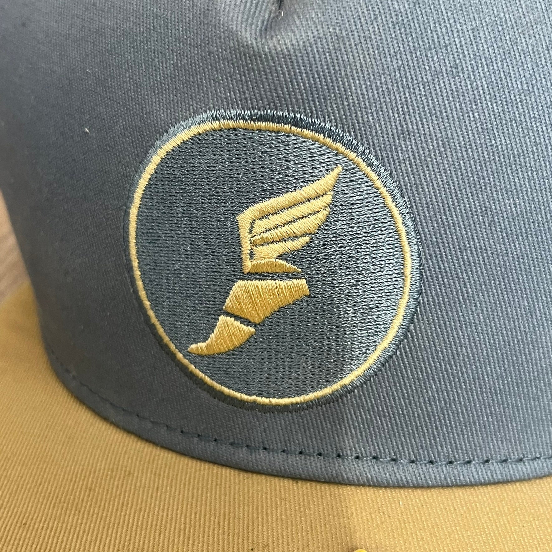 Team Fortress 2 Scout BLU LootCrate Hat is a blue and beige/yellow cap released with the 2016 LootCrate. The blue crown features an embroidered BLU Team Scout Hermes Boot logo, while the beige/yellow visor includes a BLU Team sticker and a large Team Fortress 2 logo on the underside. The hat combines official game branding with collectible LootCrate exclusivity.