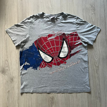 Gray 2014 Marvel tee featuring The Amazing Spider-Man 2 design with a “ripped page” effect showcasing Spider-Man’s face in the center. Text logo sits beneath the graphic for a bold cinematic touch. A collectible piece from the official movie merchandise line.