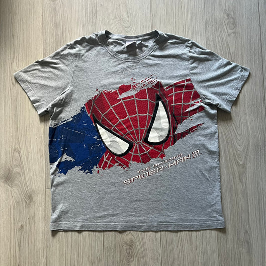 Gray 2014 Marvel tee featuring The Amazing Spider-Man 2 design with a “ripped page” effect showcasing Spider-Man’s face in the center. Text logo sits beneath the graphic for a bold cinematic touch. A collectible piece from the official movie merchandise line.
