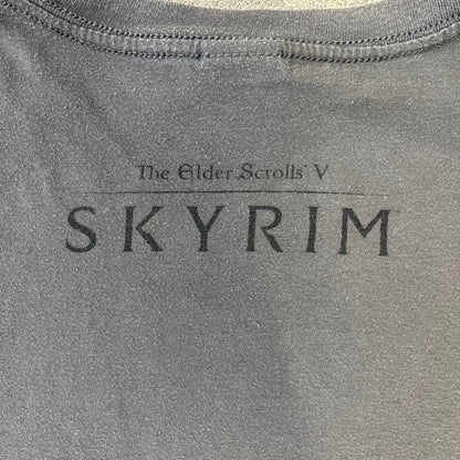 The Elder Scrolls V: Skyrim Premium Edition Tee comes from the 2012 Premium release of the game. Dark gray design with the Skyrim dragon logo printed on the front chest. The upper back has the full “The Elder Scrolls V: Skyrim” text. On the left sleeve there is a text in Dragon language. Made on a Gildan blank.