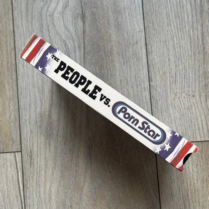 The People Vs. Porn Star is a 22-minute VHS video released in 2000 by Porn Star Skateboards in the United States. The tape features a mix of skate footage, live concert clips with featured artists, staged vignettes, and an on-camera segment with Sean “Vader” Murphy discussing the media attention surrounding the brand at the time. Original cover art includes the subtitle text “Not a Porn flick despite effort made and footage obtained” printed along the bottom.