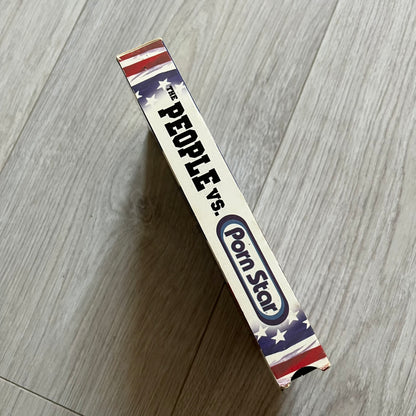 The People Vs. Porn Star is a 22-minute VHS video released in 2000 by Porn Star Skateboards in the United States. The tape features a mix of skate footage, live concert clips with featured artists, staged vignettes, and an on-camera segment with Sean “Vader” Murphy discussing the media attention surrounding the brand at the time. Original cover art includes the subtitle text “Not a Porn flick despite effort made and footage obtained” printed along the bottom.