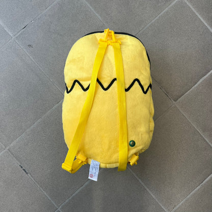 The Simpsons 1990s Homer Simpson Head Backpack is a novelty backpack shaped like a 3D Homer Simpson head. The design is fully yellow with soft sculpted facial features including eyes and nose, a molded mouth, and protruding ears. The hair detail wraps around the back, with the top strands functioning as a hanger. It includes yellow shoulder straps and a single main compartment.