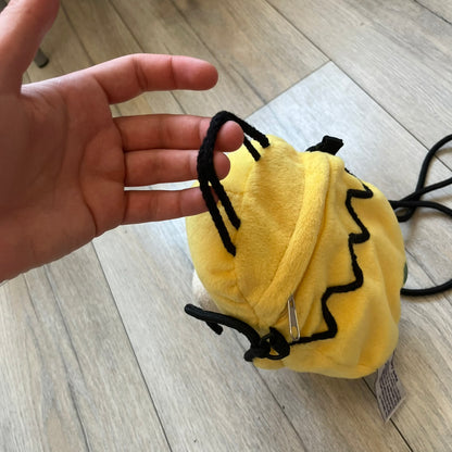 The Simpsons 1990s Homer Simpson Head Shoulder bag is shaped like a 3D Homer Simpson head. The design is yellow with soft sculpted facial features including eyes and nose, a molded beige mouth, and protruding ears. The hair detail wraps around the back, with the top strands functioning as a hanger. It includes a black string and a single main compartment.