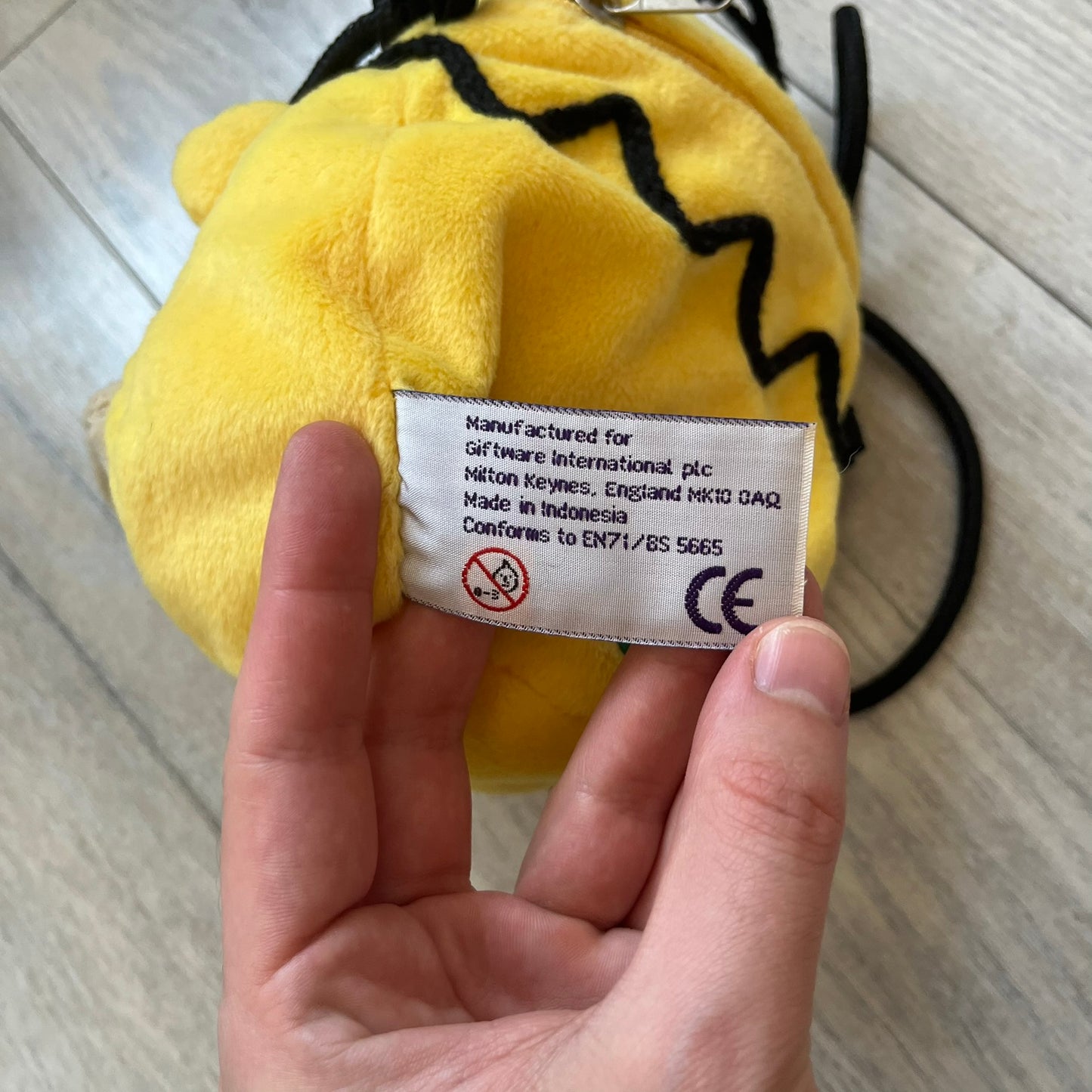 The Simpsons 1990s Homer Simpson Head Shoulder bag is shaped like a 3D Homer Simpson head. The design is yellow with soft sculpted facial features including eyes and nose, a molded beige mouth, and protruding ears. The hair detail wraps around the back, with the top strands functioning as a hanger. It includes a black string and a single main compartment.