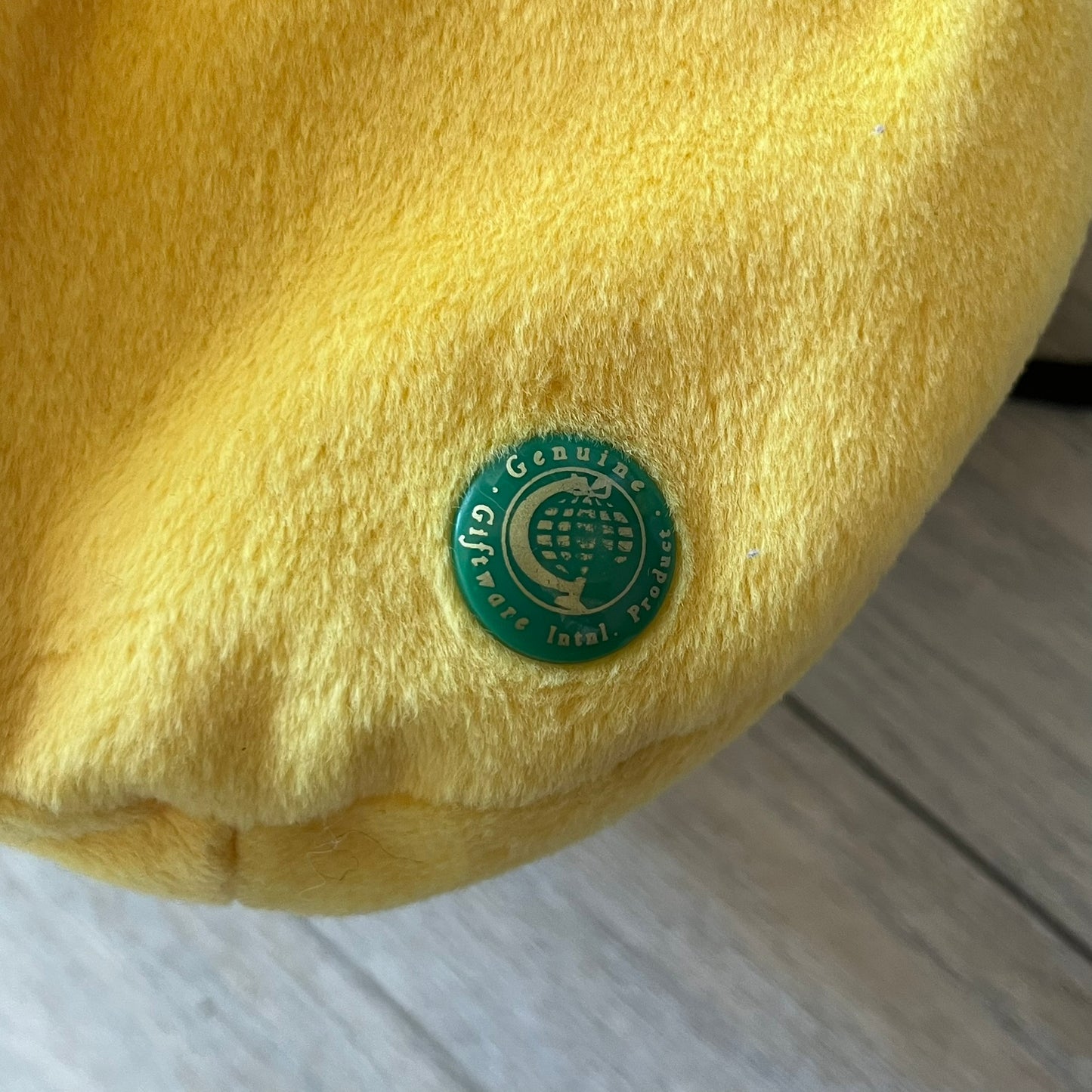 The Simpsons 1990s Homer Simpson Head Shoulder bag is shaped like a 3D Homer Simpson head. The design is yellow with soft sculpted facial features including eyes and nose, a molded beige mouth, and protruding ears. The hair detail wraps around the back, with the top strands functioning as a hanger. It includes a black string and a single main compartment.
