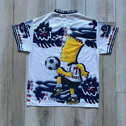 Officially licensed 1999 The Simpsons World Cup T-shirt for England. Lightweight white polyester tee featuring an all-over graphic design. The front shows Bart Simpson kicking a football, dressed in a white tee, with multiple England three-lions emblems layered across the background from top to bottom. Red “Bart” text details appear on the sleeve hems, with Matt Groening / The Simpsons ©1999 licensing printed beneath the main graphic.&nbsp;The back mirrors the artwork in a flipped layout, showing Bart from 