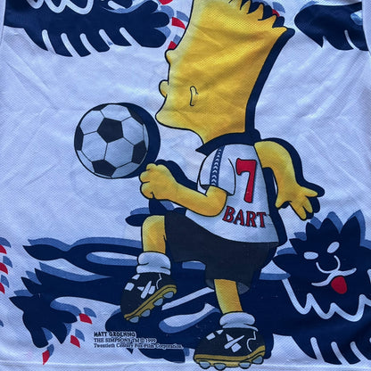 Officially licensed 1999 The Simpsons World Cup T-shirt for England. Lightweight white polyester tee featuring an all-over graphic design. The front shows Bart Simpson kicking a football, dressed in a white tee, with multiple England three-lions emblems layered across the background from top to bottom. Red “Bart” text details appear on the sleeve hems, with Matt Groening / The Simpsons ©1999 licensing printed beneath the main graphic.&nbsp;The back mirrors the artwork in a flipped layout, showing Bart from 