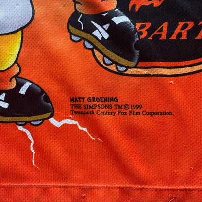 Officially licensed 1999 The Simpsons World Cup Netherlands Tee. Orange lightweight polyester tee with an all-over graphic design. The front features Bart Simpson kicking a football, orange “Bart” text, white lightning graphics, and a Netherlands emblem with Bart illustrated beneath it. Black flame details on the sleeve, along with a black ribbed collar with orange lining. Matt Groening / The Simpsons ©1999 licensing is printed below the main graphic. The back repeats the design in a flipped layout, showing