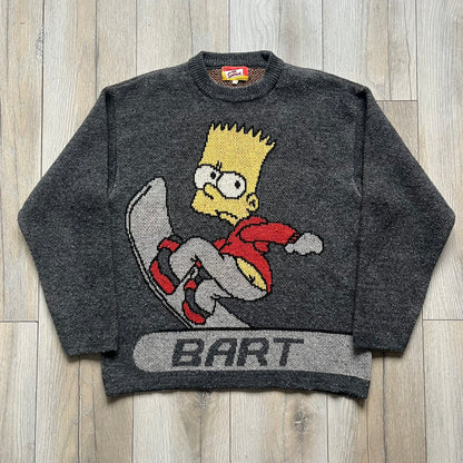 The Simpsons “Bart Freestyle” 2003 Knit Sweater is a gray knit featuring a large woven graphic of Bart snowboarding on the front, with “Bart” text placed below the character. On the back, in the same position as the front graphic, there is “Freestyle” text.&nbsp;It includes a Matt Groening The Simpsons 2003 FOX neck tag.