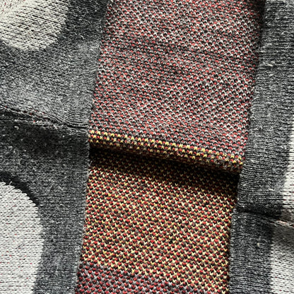 The Simpsons “Bart Freestyle” 2003 Knit Sweater is a gray knit featuring a large woven graphic of Bart snowboarding on the front, with “Bart” text placed below the character. On the back, in the same position as the front graphic, there is “Freestyle” text.&nbsp;It includes a Matt Groening The Simpsons 2003 FOX neck tag.