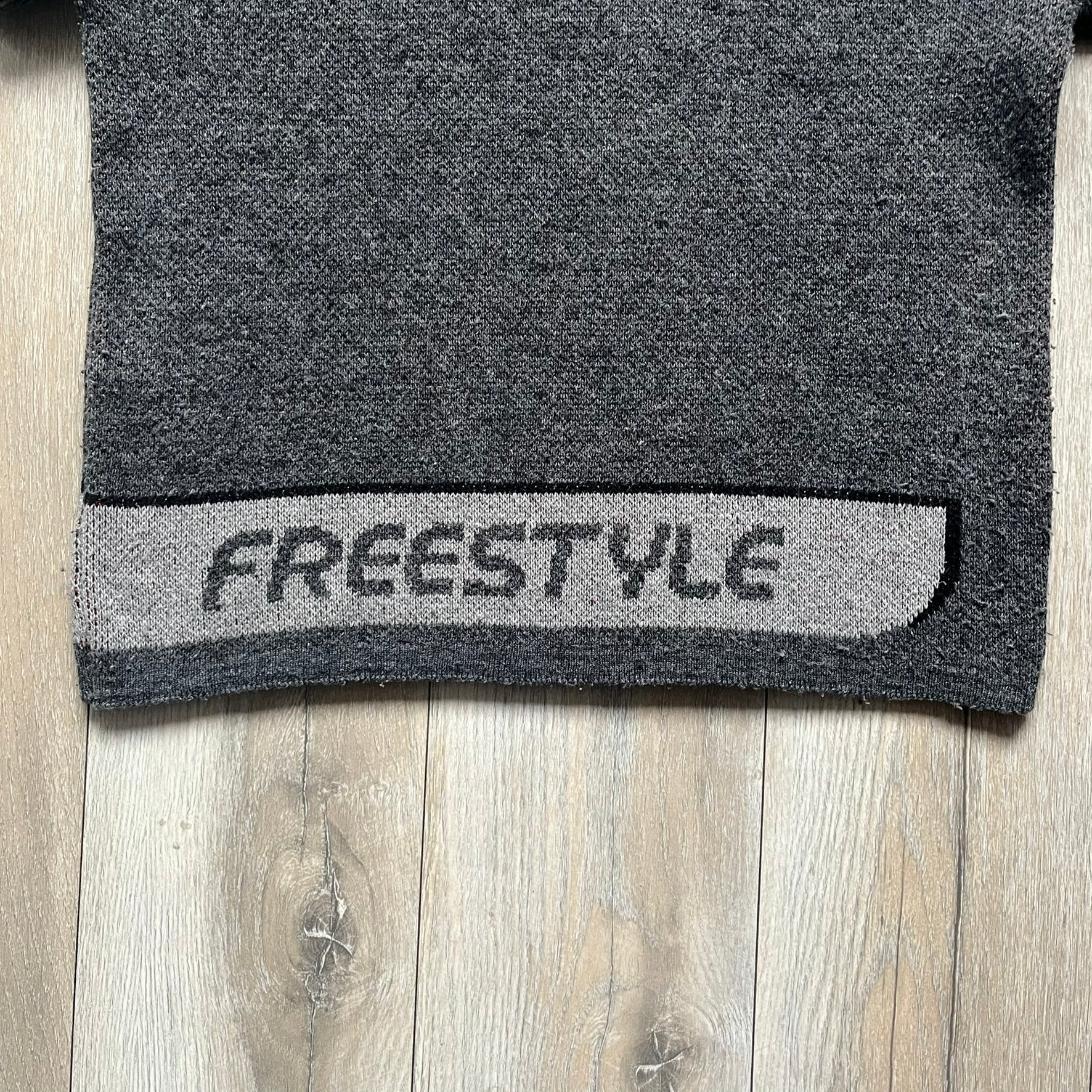 The Simpsons “Bart Freestyle” 2003 Knit Sweater is a gray knit featuring a large woven graphic of Bart snowboarding on the front, with “Bart” text placed below the character. On the back, in the same position as the front graphic, there is “Freestyle” text.&nbsp;It includes a Matt Groening The Simpsons 2003 FOX neck tag.
