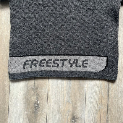 The Simpsons “Bart Freestyle” 2003 Knit Sweater is a gray knit featuring a large woven graphic of Bart snowboarding on the front, with “Bart” text placed below the character. On the back, in the same position as the front graphic, there is “Freestyle” text.&nbsp;It includes a Matt Groening The Simpsons 2003 FOX neck tag.