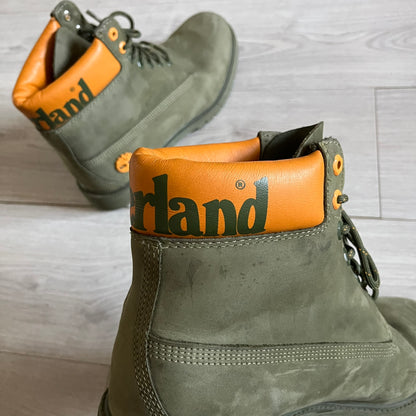 Timberland 6-Inch x Zoolander Olive Boots, model A1QTY / A2040. These collaboration boots feature an olive/army green upper with an orange metal Timberland logo on the side and an orange padded collar with large olive Timberland text. The laces are olive with small orange speckled details, matched by orange lace eyelets. This Zoolander collaboration was not sold in the United States and is considered extremely difficult to find.