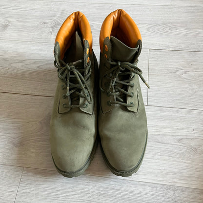 Timberland 6-Inch x Zoolander Olive Boots, model A1QTY / A2040. These collaboration boots feature an olive/army green upper with an orange metal Timberland logo on the side and an orange padded collar with large olive Timberland text. The laces are olive with small orange speckled details, matched by orange lace eyelets. This Zoolander collaboration was not sold in the United States and is considered extremely difficult to find.