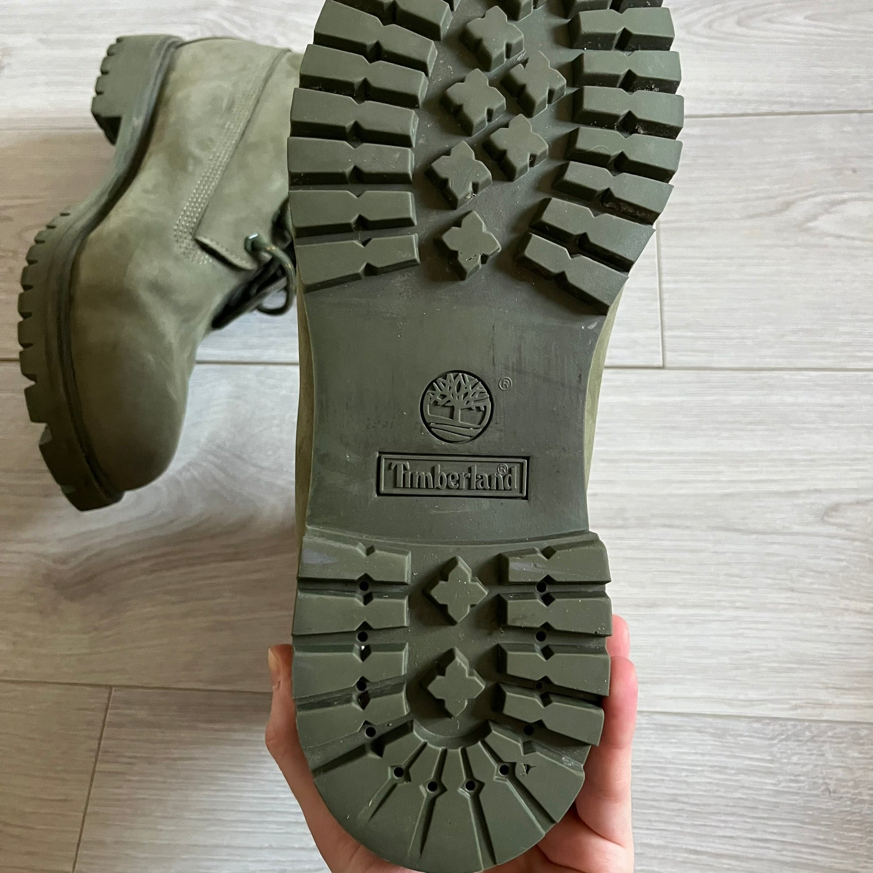 Timberland 6-Inch x Zoolander Olive Boots, model A1QTY / A2040. These collaboration boots feature an olive/army green upper with an orange metal Timberland logo on the side and an orange padded collar with large olive Timberland text. The laces are olive with small orange speckled details, matched by orange lace eyelets. This Zoolander collaboration was not sold in the United States and is considered extremely difficult to find.