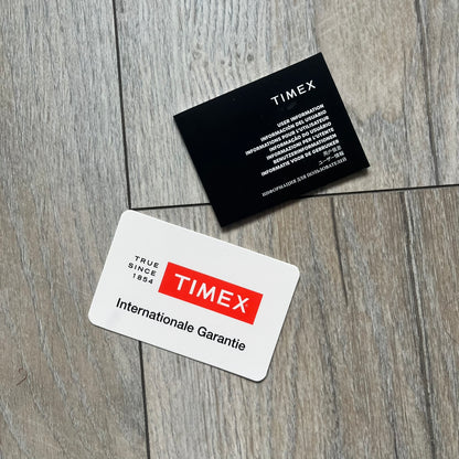 Timex x Maison Margiela MM6 Gift Set TWG065600 is a collaborative reinterpretation of the classic Timex T80, released on October 24, 2024. Crafted from polished and brushed stainless steel, it features a 36mm digital case with Timex branding and a distinctive 0–23 numeral layout, including a subtle circled “6” nod to MM6 design language. The watch offers 100 ft water resistance, mineral glass, backlight, alarm, timer, and date functions, and is presented as a 2-in-1 gift set with an additional standalone st