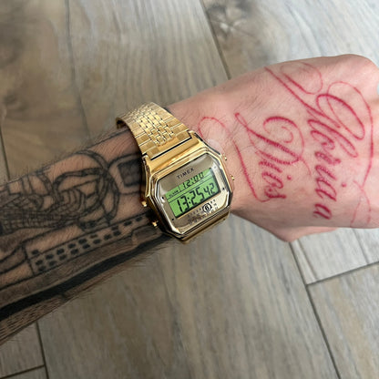 Timex x Maison Margiela MM6 Gold Watch + Bracelet Gift Set TWG067500QY is a collaborative reinterpretation of the classic Timex T80, released on October 24, 2024. Crafted from polished and brushed stainless steel, it features a 36mm digital case with Timex branding and a distinctive 0–23 numeral layout, including a subtle circled “6” nod to MM6 design language. The watch offers 100 ft water resistance, mineral glass, backlight, alarm, timer, and date functions, and is presented as a 2-in-1 gift set with an 