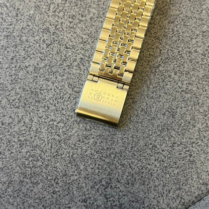 Timex x Maison Margiela MM6 Gold Watch + Bracelet Gift Set TWG067500QY is a collaborative reinterpretation of the classic Timex T80, released on October 24, 2024. Crafted from polished and brushed stainless steel, it features a 36mm digital case with Timex branding and a distinctive 0–23 numeral layout, including a subtle circled “6” nod to MM6 design language. The watch offers 100 ft water resistance, mineral glass, backlight, alarm, timer, and date functions, and is presented as a 2-in-1 gift set with an 