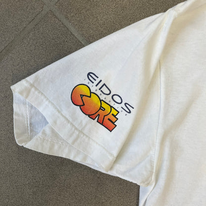 Tomb Raider III 1998 “Lara’s Back” White Tee is a boxy white T-shirt made on a Sierra Teez blank, with a stone-styled Tomb Raider III: Adventures of Lara Croft logo on the front. The back has a low-poly graphic of Lara Croft ass with “Lara’s Back...” text underneath, and the sleeve carries Eidos and Core logos.