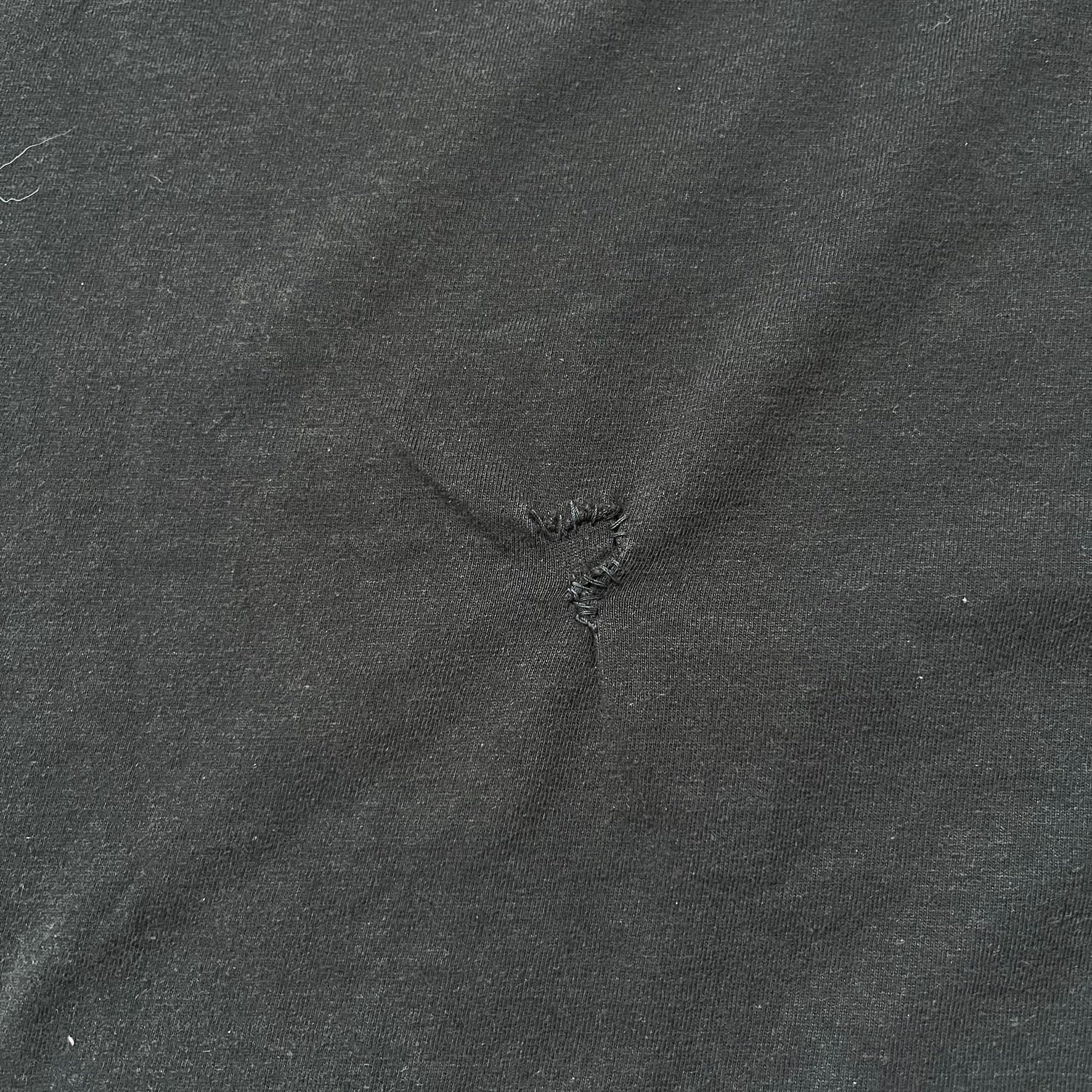 Tomb Raider Lara Croft 2006 Legend Tee is a black V-neck T-shirt made from 100% cotton on a Hanes blank. The front features the Lara Croft: Tomb Raider Legend cover graphic with Lara Croft’s face and the game title printed below. A white Eidos logo is printed on the sleeve, referencing the official game publisher.