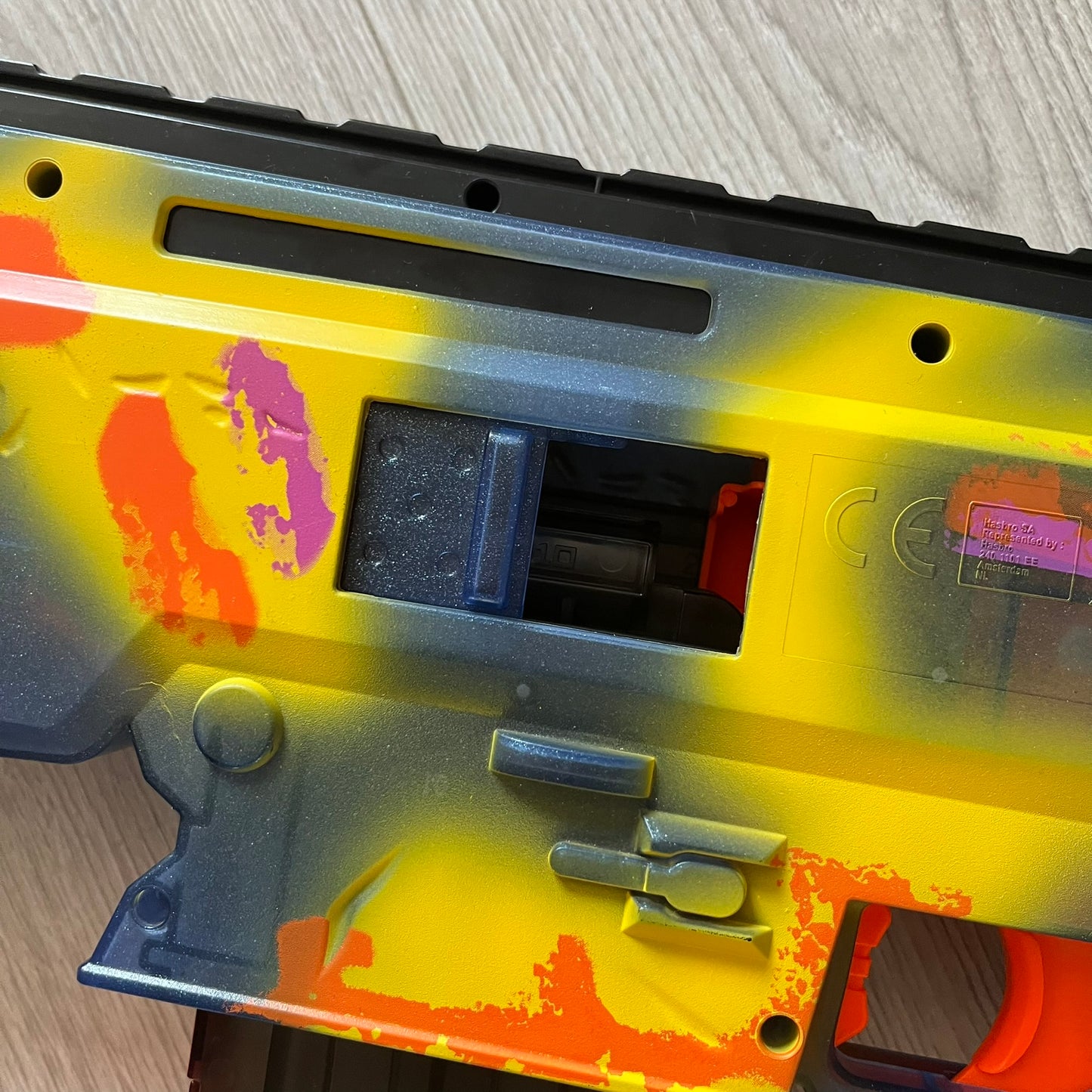 Colorful gun with a yellow and orange design on a wooden surface