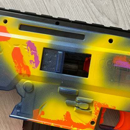 Colorful gun with a yellow and orange design on a wooden surface
