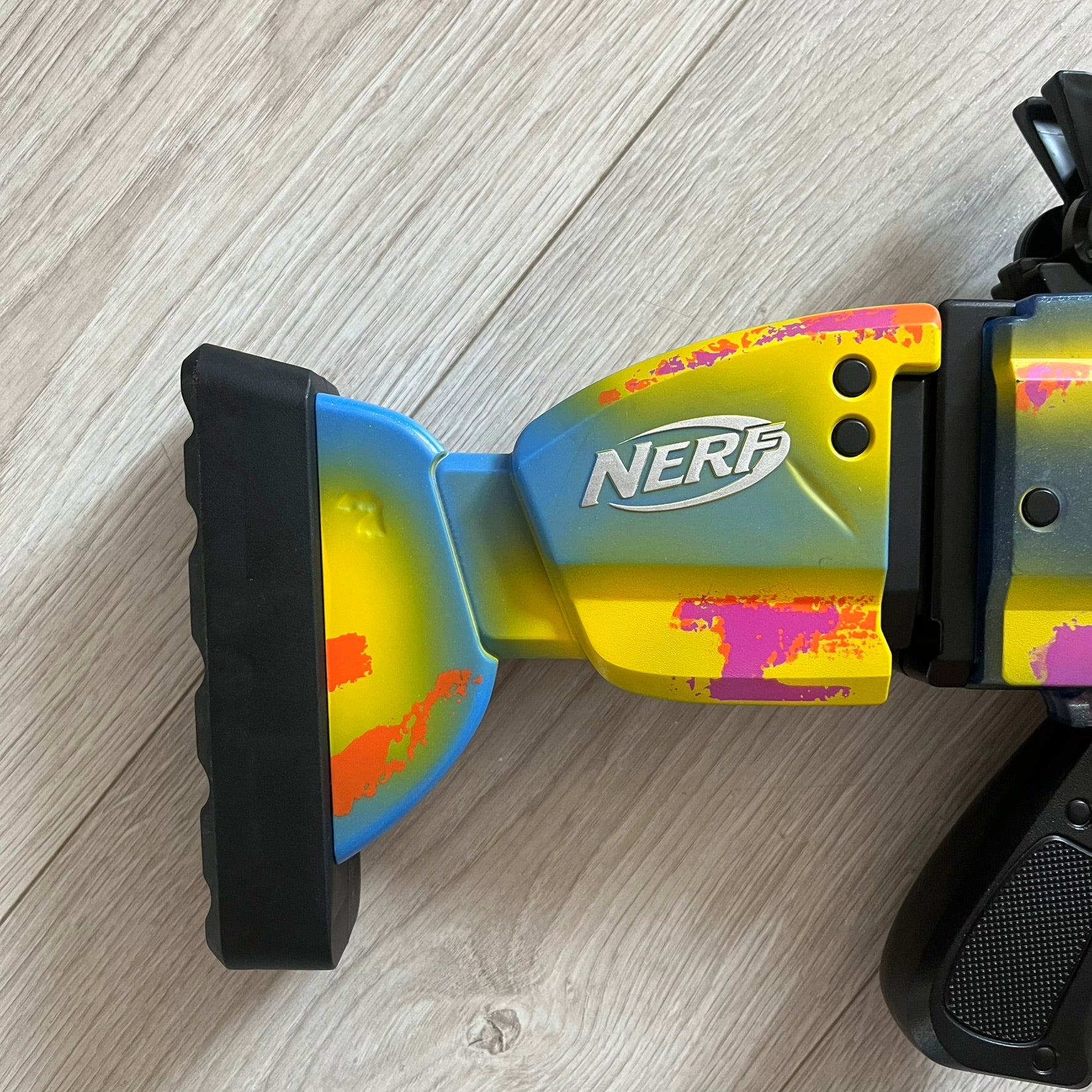 Colorful toy bow with NERF branding on a wooden surface