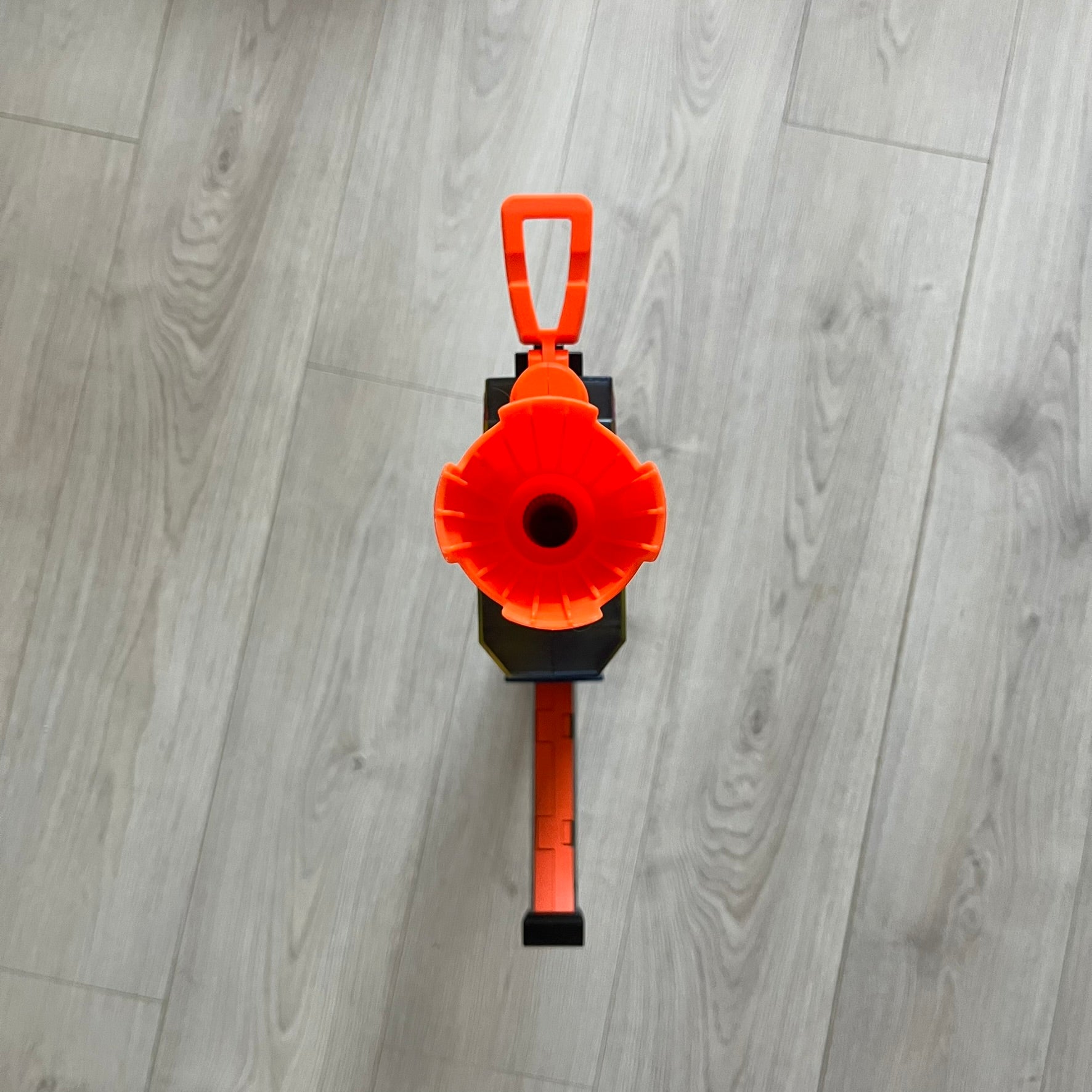 Orange and black tool on a gray wooden floor