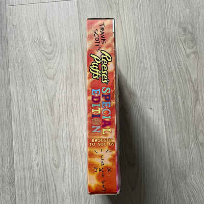 Travis Scott x Reese’s Puffs Cereal released in 2019 as a collaboration between Travis Scott and General Mills. The limited-edition box features the rapper on the front with his arms spread behind a bowl of Reese’s Puffs, and an action figure graphic on the back with the Cactus Jack logo. Originally sold at Target and Walmart, this collector’s item is not fit for human consumption.