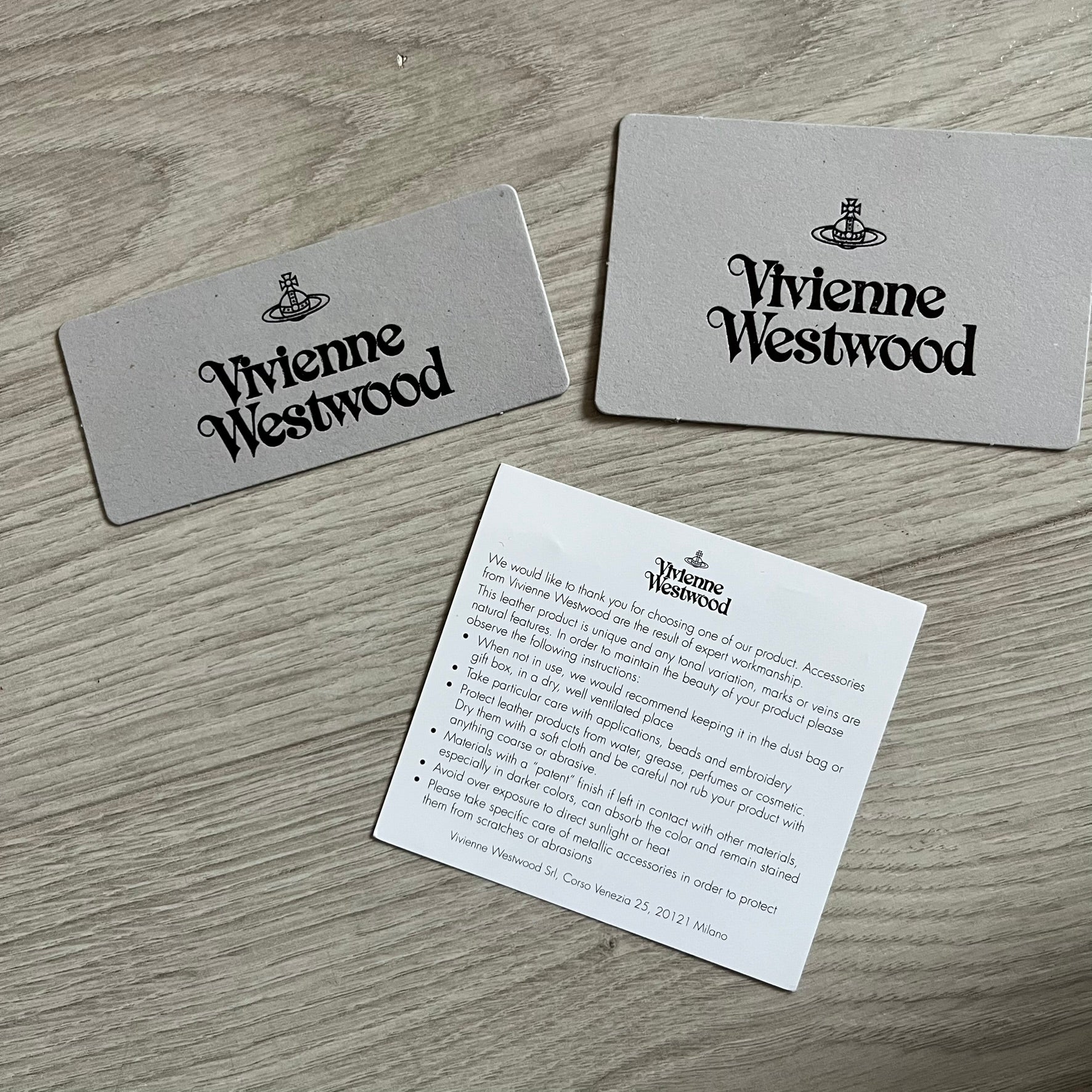 Vivienne Westwood Flat Chain Card Holder in black leather, featuring the signature silver Orb emblem on the corner. Designed with four compartments - three main slots and one smaller front pocket. Completed with a flat chain and an engraved Vivienne Westwood loop for a refined finish.