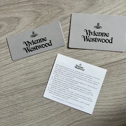 Vivienne Westwood Flat Chain Card Holder in black leather, featuring the signature silver Orb emblem on the corner. Designed with four compartments - three main slots and one smaller front pocket. Completed with a flat chain and an engraved Vivienne Westwood loop for a refined finish.