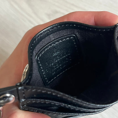 Vivienne Westwood Flat Chain Card Holder in black leather, featuring the signature silver Orb emblem on the corner. Designed with four compartments - three main slots and one smaller front pocket. Completed with a flat chain and an engraved Vivienne Westwood loop for a refined finish.