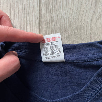 WWE John Cena “Hustle Loyalty Respect” Tee in navy, printed on a classic Screen Stars blank. Features a large front graphic of John Cena with big red, white, and blue lettering behind / in front of him and the WWE logo beside. A staple piece from Cena’s prime wrestling era.