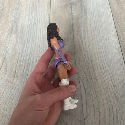 WWE Mattel Chelsea Green Series 122 Action Figure is a 6-inch articulated figure from the WWE Basic Series. It features approximately 10 points of articulation for poseability and includes TrueFX facial detailing for a more realistic appearance. The figure depicts Chelsea Green wearing purple ring attire paired with white high boots. It is designed to replicate WWE match action and display poses.