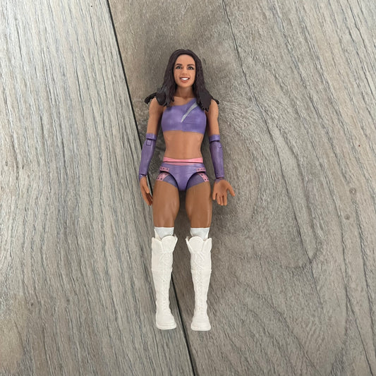 WWE Mattel Chelsea Green Series 122 Action Figure is a 6-inch articulated figure from the WWE Basic Series. It features approximately 10 points of articulation for poseability and includes TrueFX facial detailing for a more realistic appearance. The figure depicts Chelsea Green wearing purple ring attire paired with white high boots. It is designed to replicate WWE match action and display poses.