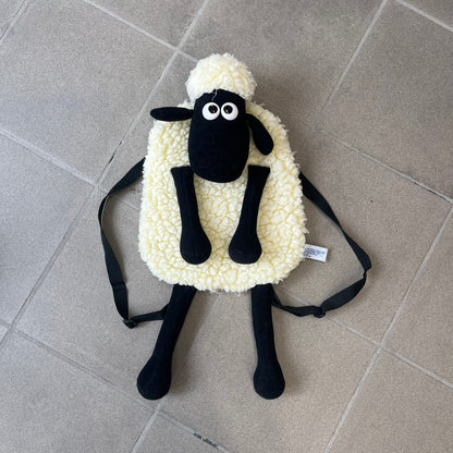 Wallace &amp; Gromit “Shaun The Sheep” 1990’s Backpack is a character-shaped backpack designed as Shaun the Sheep with black shoulder straps running from the bottom to the top of the body. The arms, legs, and ears are movable, and the face features plastic eyes. It includes one large main storage compartment, dating to the late 1980s-1990s production period.
