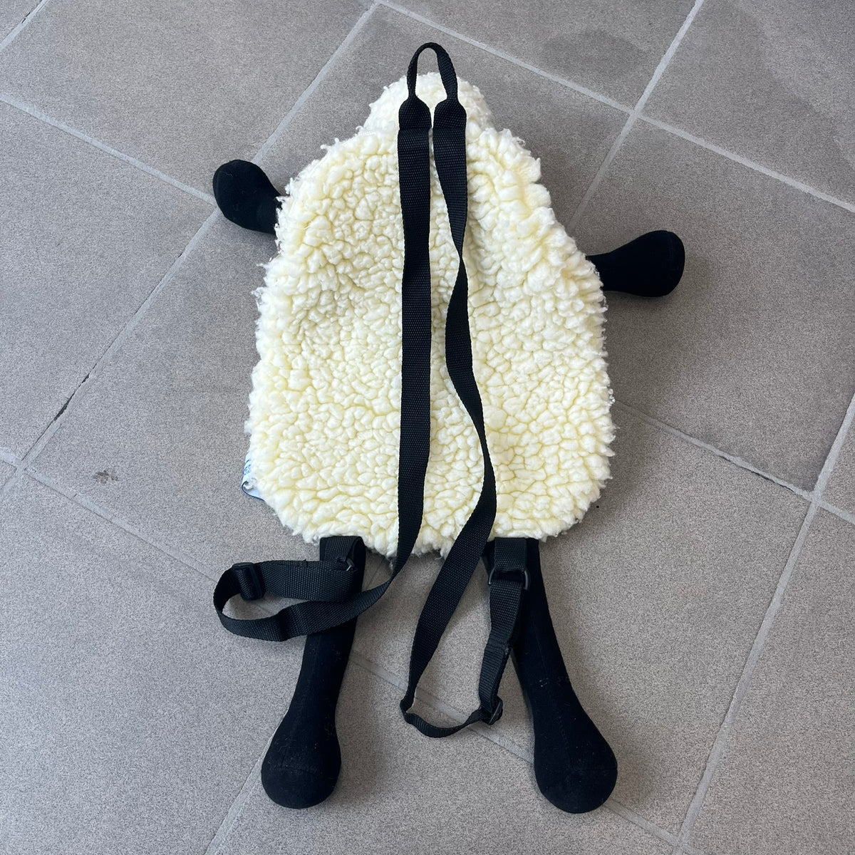 Wallace &amp; Gromit “Shaun The Sheep” 1990’s Backpack is a character-shaped backpack designed as Shaun the Sheep with black shoulder straps running from the bottom to the top of the body. The arms, legs, and ears are movable, and the face features plastic eyes. It includes one large main storage compartment, dating to the late 1980s-1990s production period.