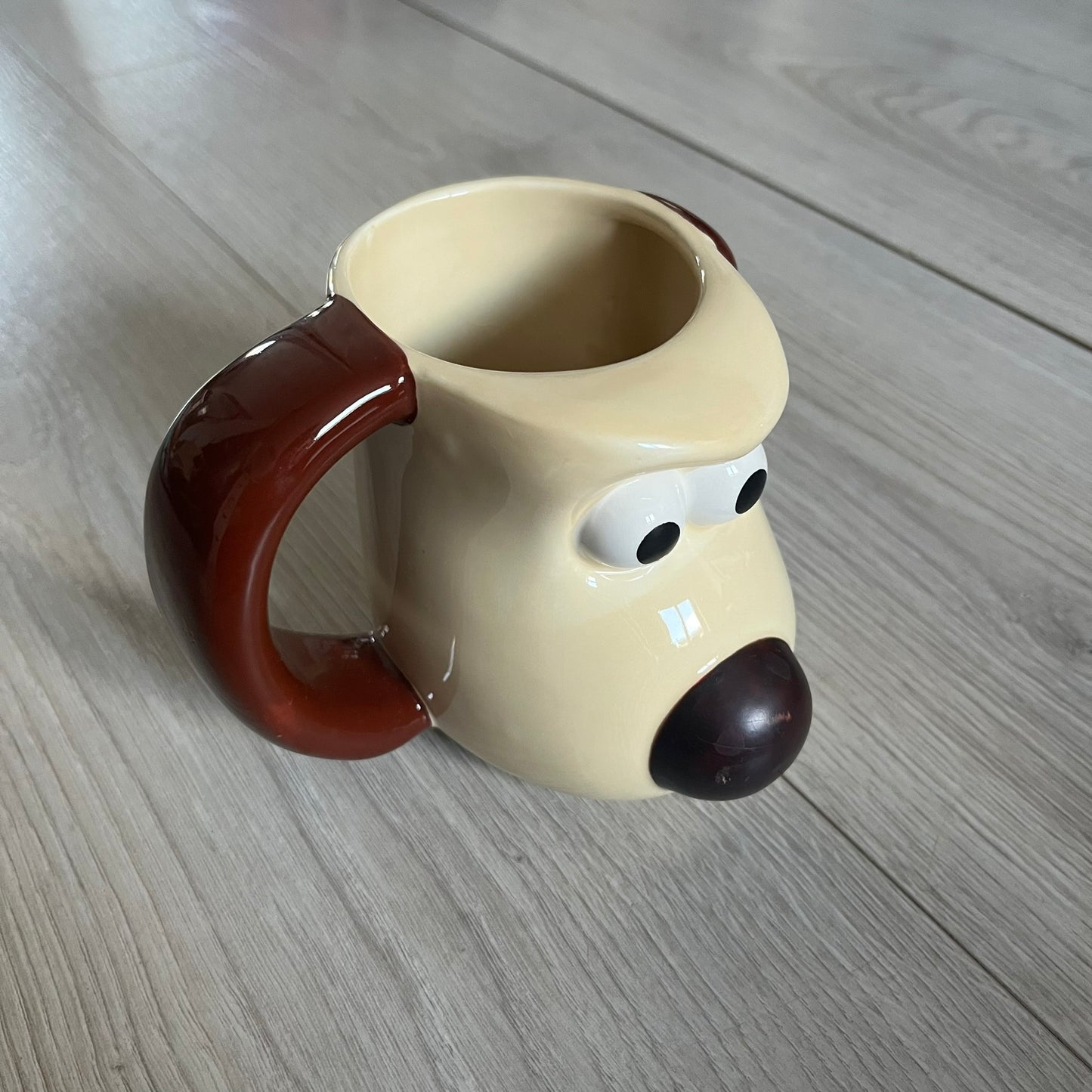 This 2005 Wallace &amp; Gromit ceramic mug captures the beloved character in full 3D detail, with protruding eyes and nose and an irregular sculpted form. One ear doubles as the handle, adding playful functionality to the design. Created exclusively for PG Tips, it’s finished with official licensing and copyright on the base.