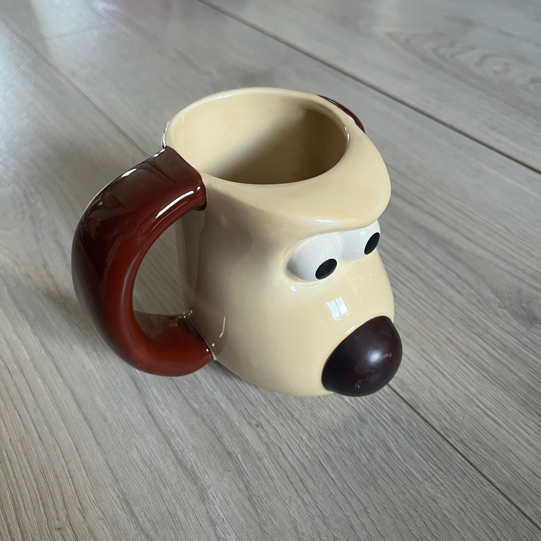 This 2005 Wallace &amp; Gromit ceramic mug captures the beloved character in full 3D detail, with protruding eyes and nose and an irregular sculpted form. One ear doubles as the handle, adding playful functionality to the design. Created exclusively for PG Tips, it’s finished with official licensing and copyright on the base.
