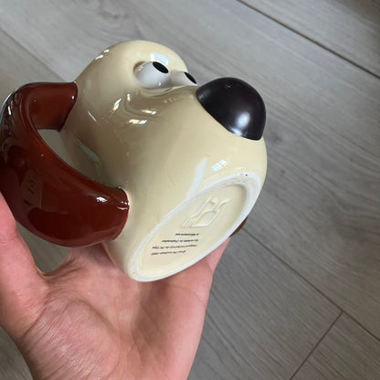 This 2005 Wallace &amp; Gromit ceramic mug captures the beloved character in full 3D detail, with protruding eyes and nose and an irregular sculpted form. One ear doubles as the handle, adding playful functionality to the design. Created exclusively for PG Tips, it’s finished with official licensing and copyright on the base.