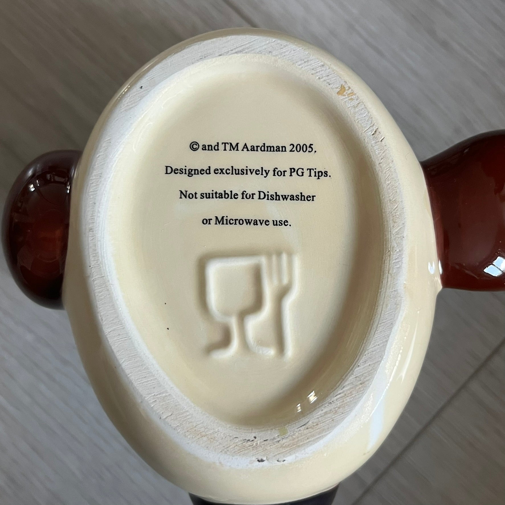 This 2005 Wallace &amp; Gromit ceramic mug captures the beloved character in full 3D detail, with protruding eyes and nose and an irregular sculpted form. One ear doubles as the handle, adding playful functionality to the design. Created exclusively for PG Tips, it’s finished with official licensing and copyright on the base.
