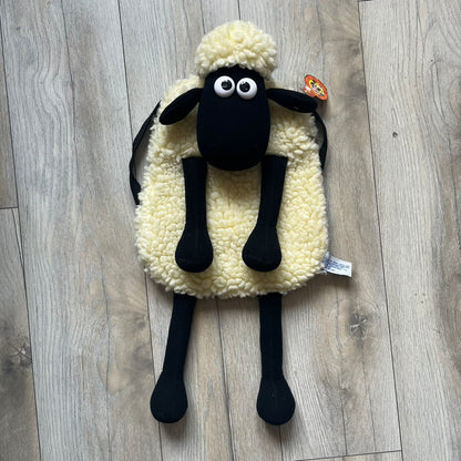 Wallace &amp; Gromit “Shaun The Sheep” 1990’s Backpack is a character-shaped backpack designed as Shaun the Sheep with black shoulder straps running from the bottom to the top of the body. The arms, legs, and ears are movable, and the face features plastic eyes. It includes a Wallace &amp; Gromit paper tag, a material tag, and one large main storage compartment, dating to the late 1980s-1990s production period.