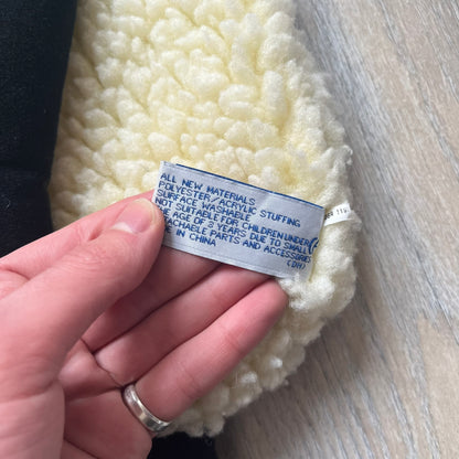 Wallace &amp; Gromit “Shaun The Sheep” 1990’s Backpack is a character-shaped backpack designed as Shaun the Sheep with black shoulder straps running from the bottom to the top of the body. The arms, legs, and ears are movable, and the face features plastic eyes. It includes a Wallace &amp; Gromit paper tag, a material tag, and one large main storage compartment, dating to the late 1980s-1990s production period.