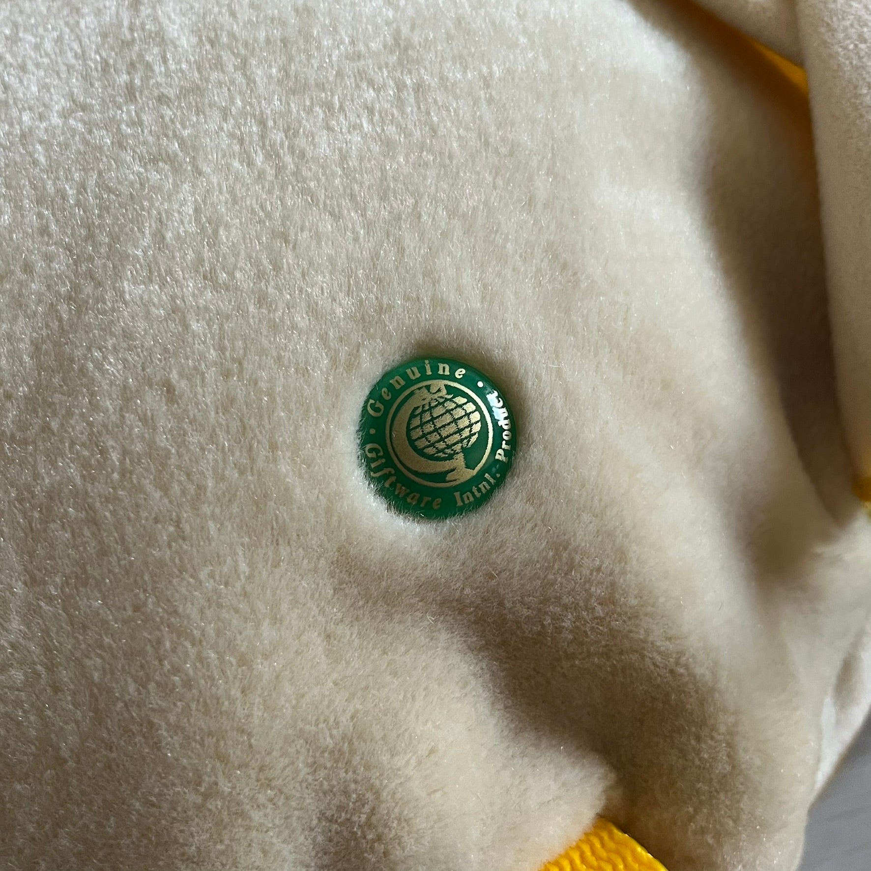 The Wallace and Gromit Gromit Plush Backpack is a 1990s licensed item produced by Aardman Animations. It features Gromit dressed in his bright yellow PVC raincoat and matching hat, as seen in The Wrong Trousers. The backpack is made from soft plush fabric with plastic eyes, a hard black nose, and a genuine stamp confirming official production. The bag opens from the side and includes adjustable shoulder straps for wearability