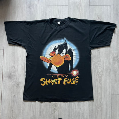 Black Warner Bros 1996 Daffy Duck ‘Very Short Fuse’ Tee showcasing a classic angry Daffy graphic and yellow text on the front. Vintage 1996 licensed Warner Bros merchandise with high-quality print details.