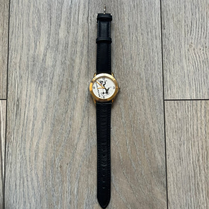 Warner Bros Sylvester 1990 Analog Watch features a gold-tone case with a white dial and black leather strap marked as genuine leather. The dial displays Sylvester with vertical “Sylvester” text, along with hour markers at 12, 3, 6, and 9. The watch uses a Japan movement and includes Warner Bros 1990 licensing engraved on the caseback